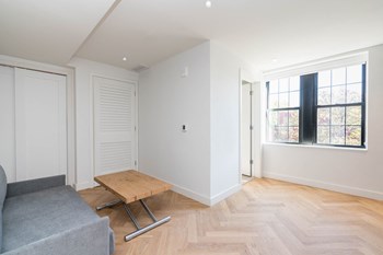 The Stanton furnished studio apartment with murphy bed, table and couch